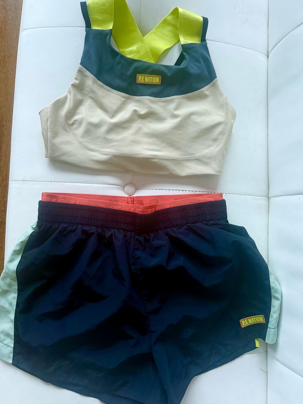 P.E Nation Cream Sports Bra with Lime Straps and Black Shorts with Accents